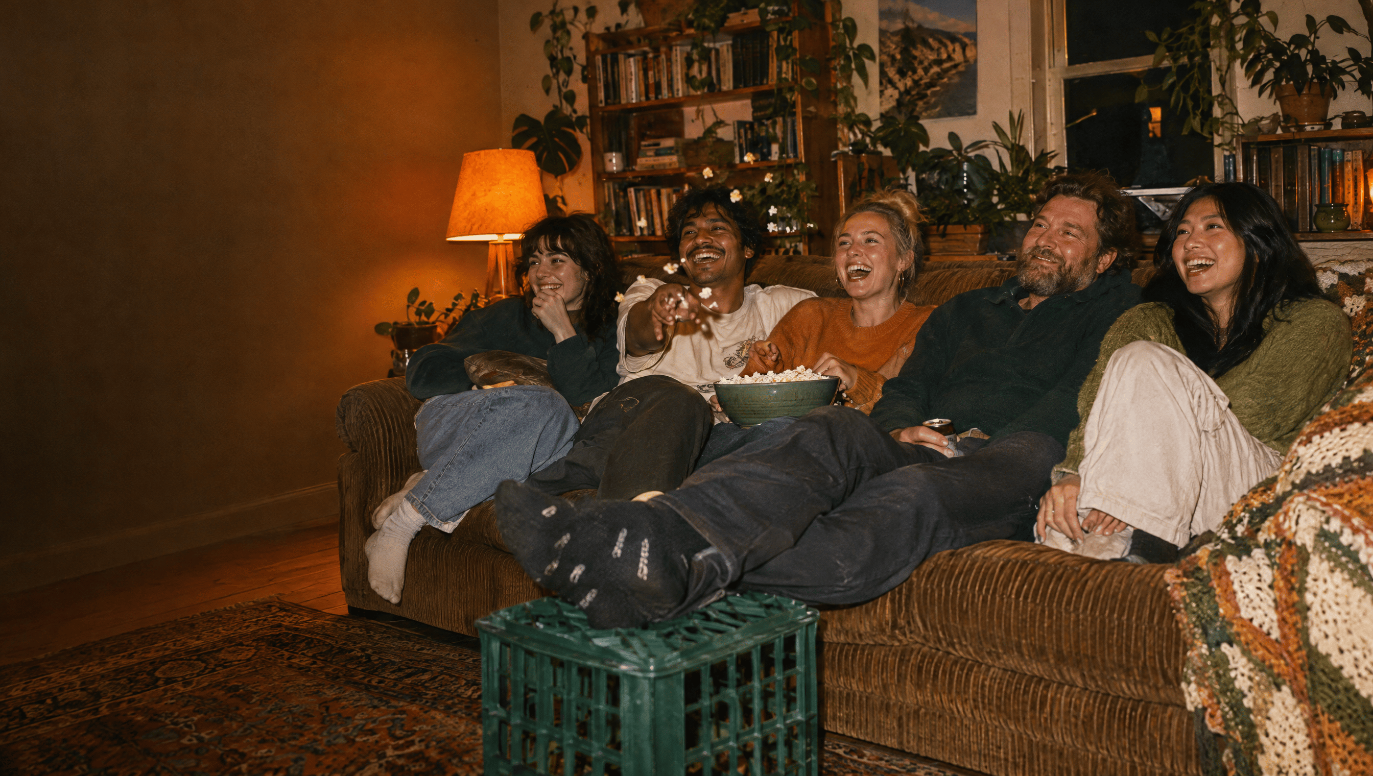 Housemates squeezed onto an old couch for movie night